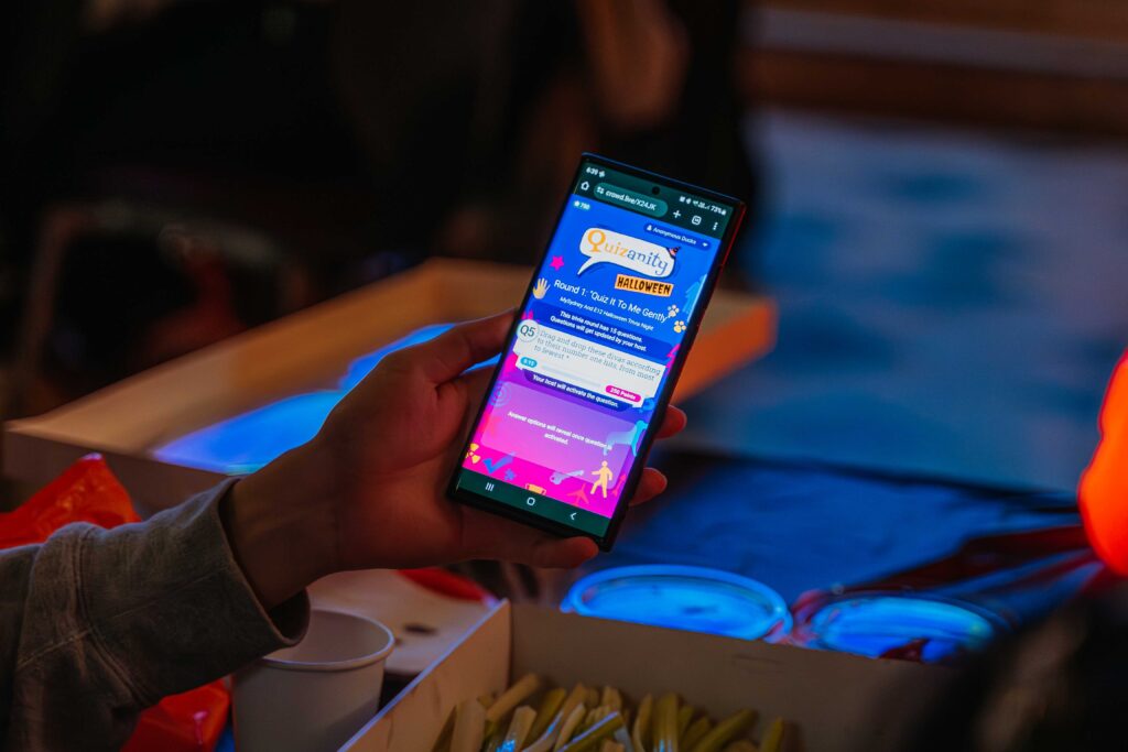 Person holding smartphone with Halloween quiz app