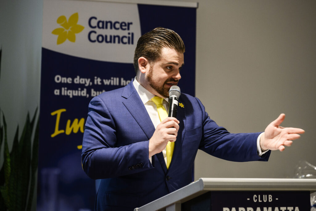 Nathan Cassar, corporate event mc speaking at Cancer Council event podium