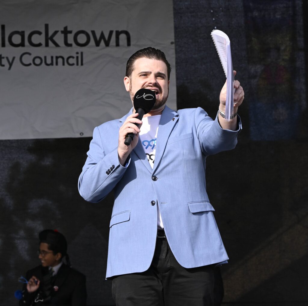 Man speaking at council event holding papers