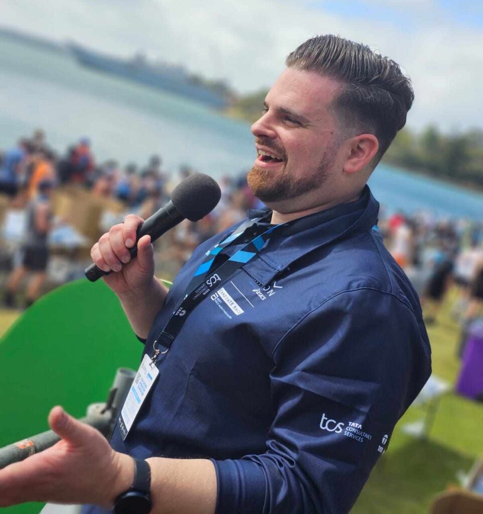 Nathan Cassar, corporate event mc speaking into microphone at outdoor waterfront event