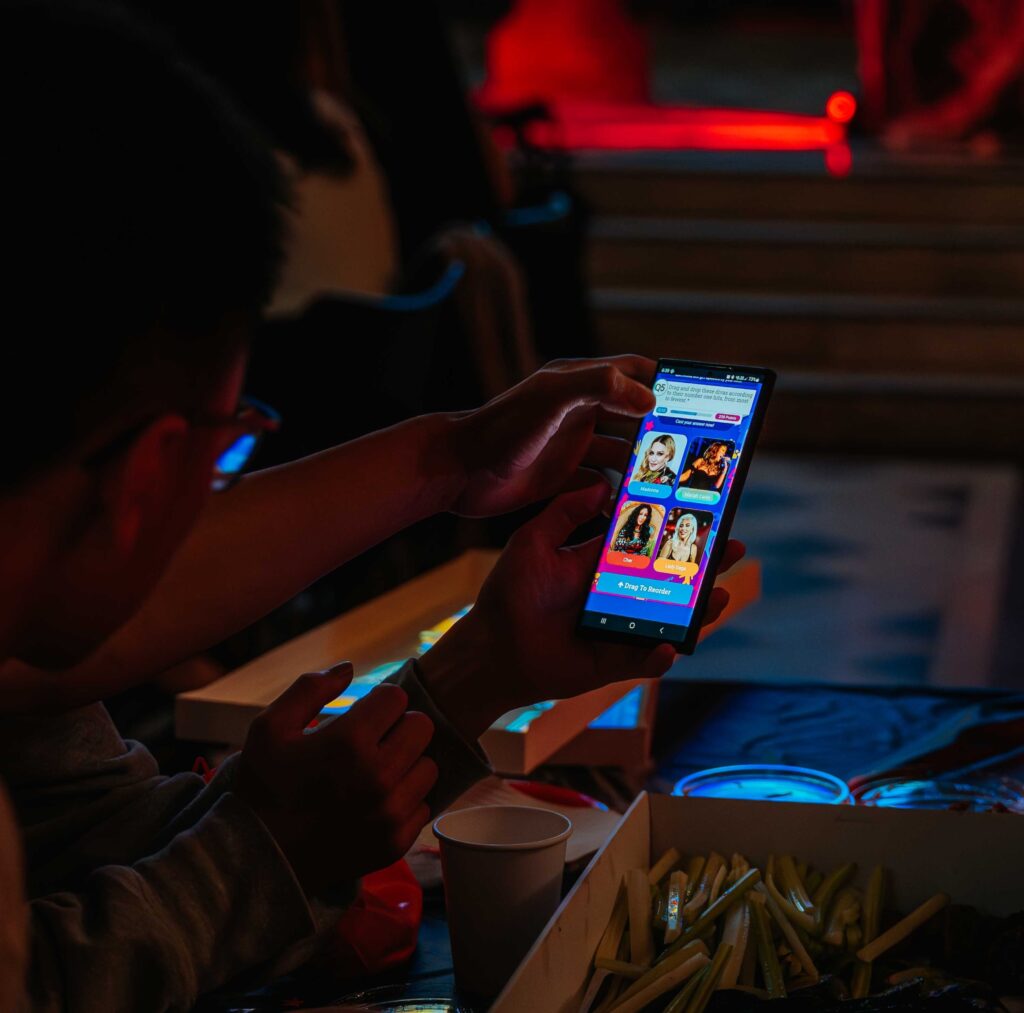 Person using smartphone quiz app at fast-food table