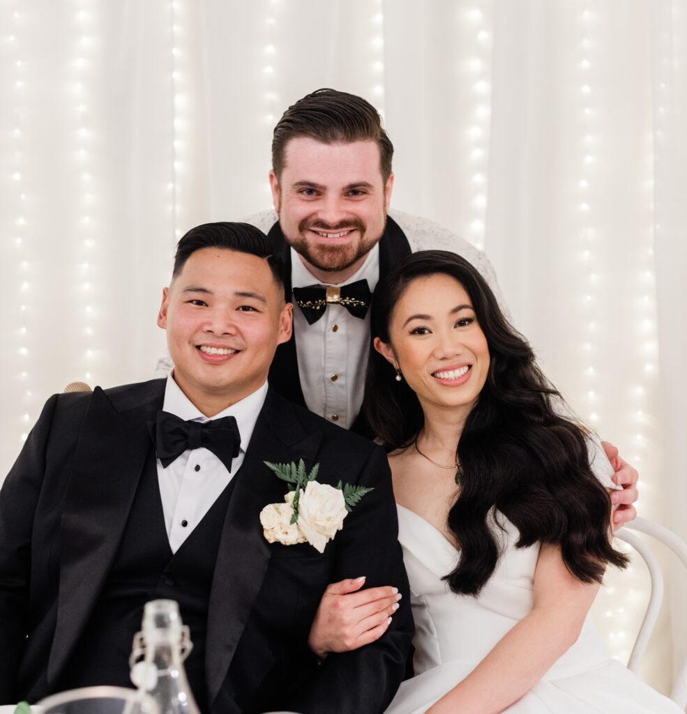 Smiling couple with friend at wedding reception with Nathan Cassar, ceremony master wedding​