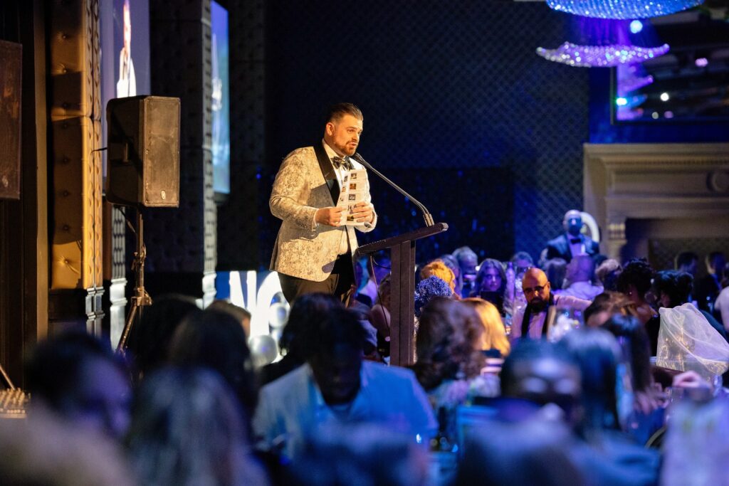 Nathan Cassar, Wedding & Corporate Master of Ceremony at podium during formal gala event