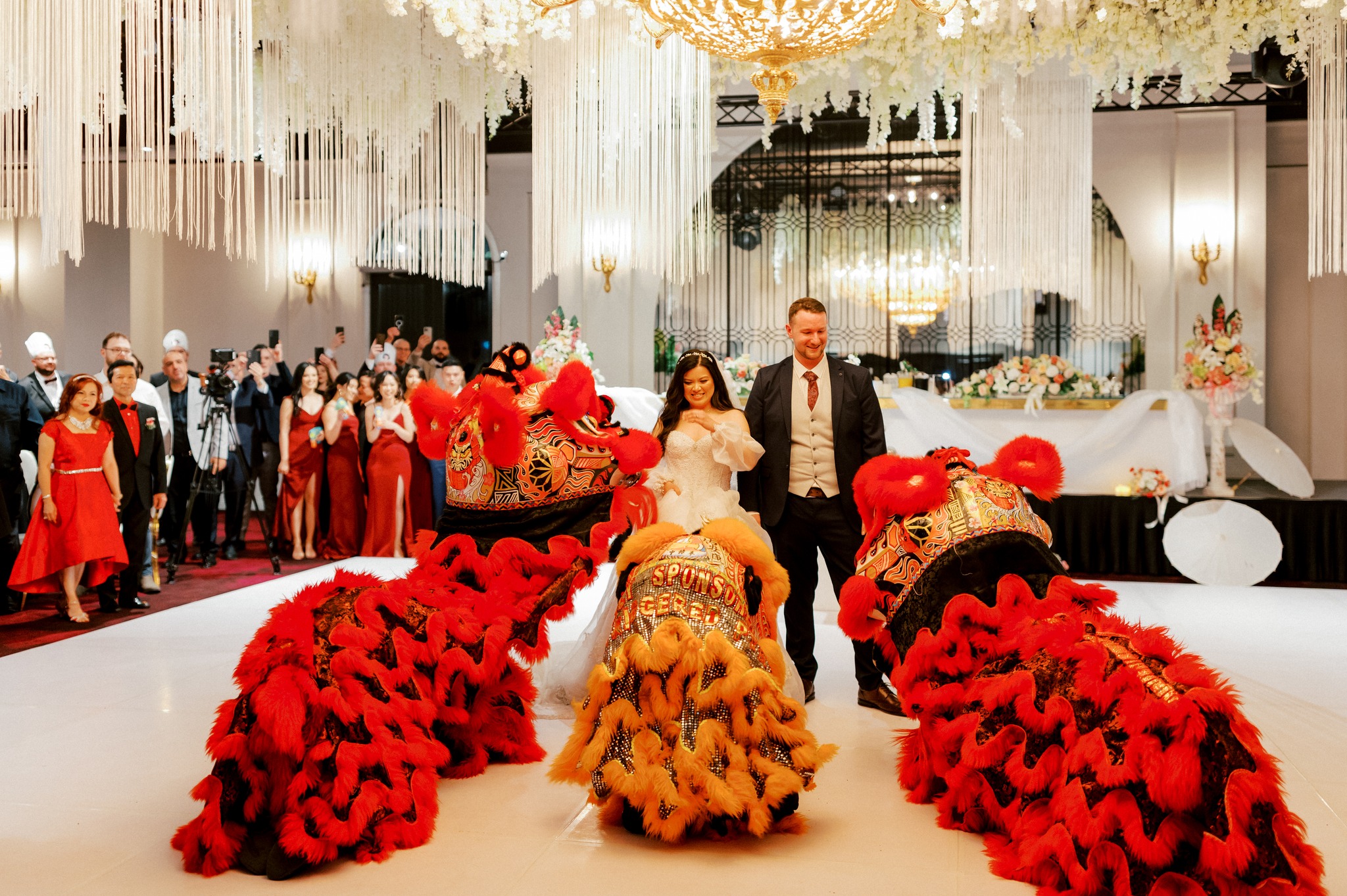 Bride and groom with lion dance performers at wedding reception