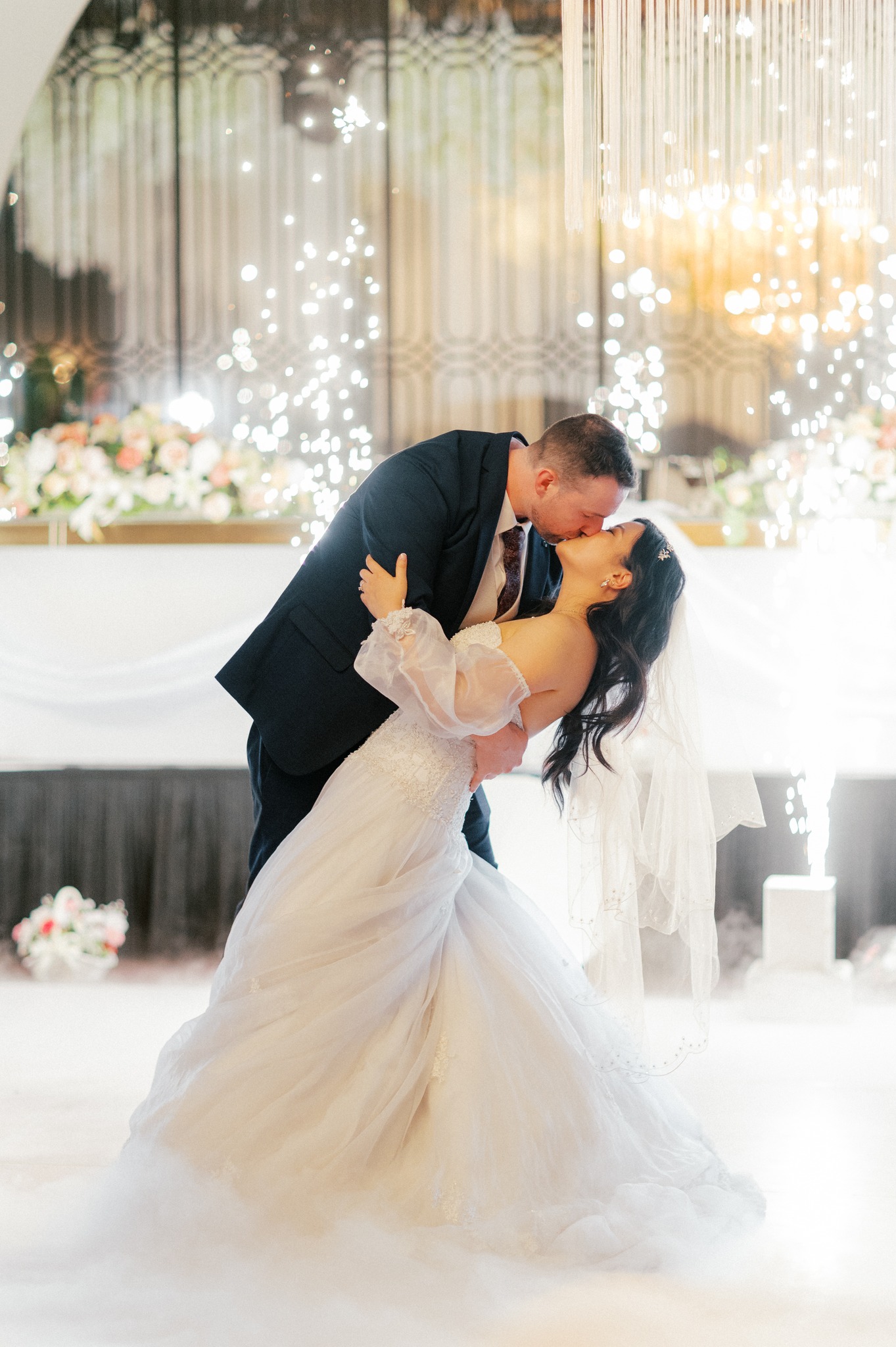 Bride and groom kissing during romantic wedding dance