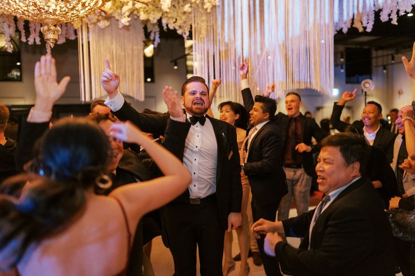 Guests dancing energetically at wedding reception indoors