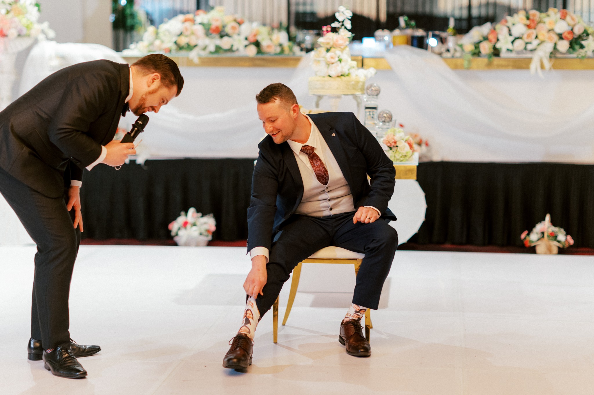 Groom showing novelty socks at wedding reception