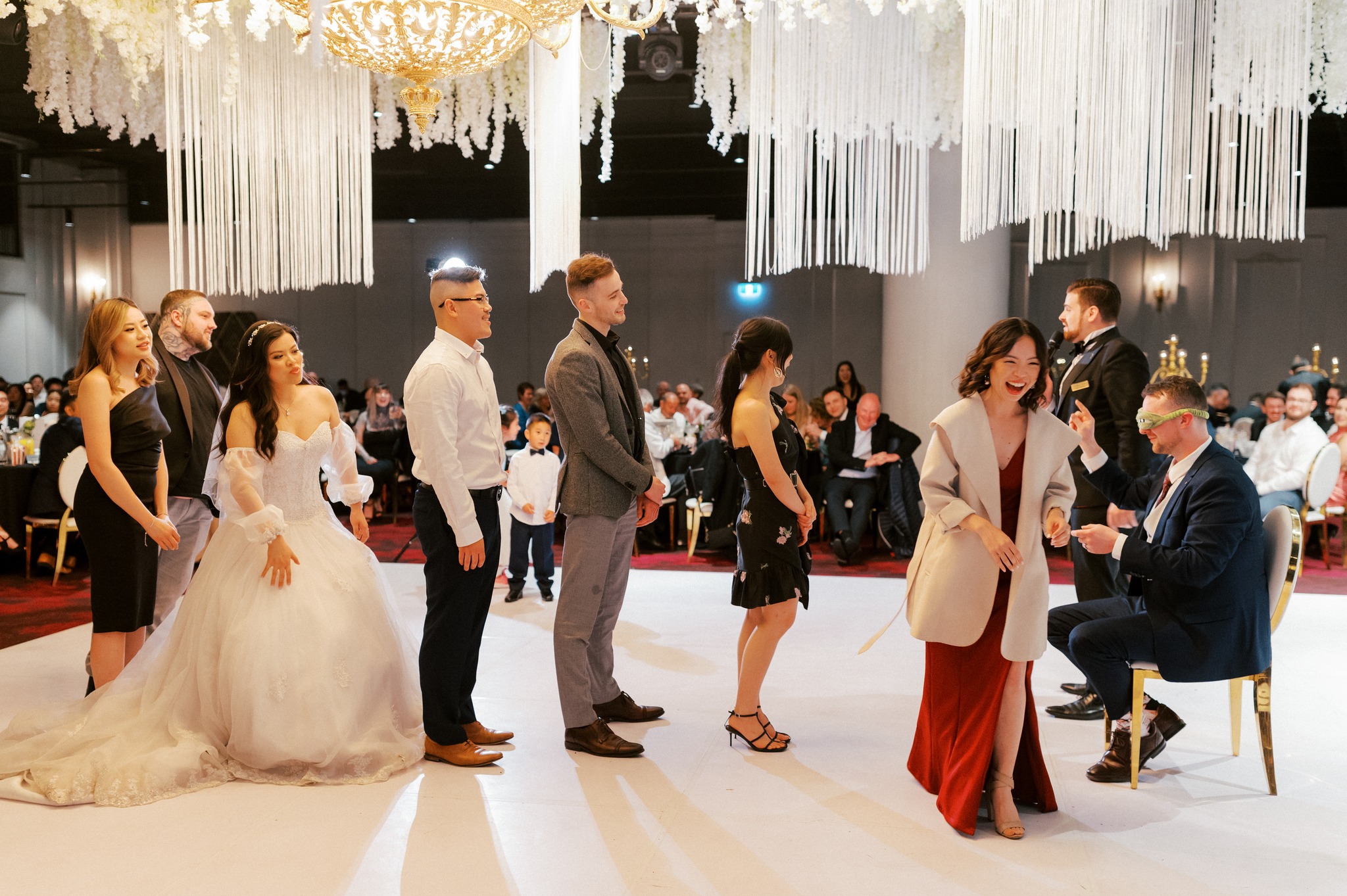 Wedding reception game with blindfolded guest and bride