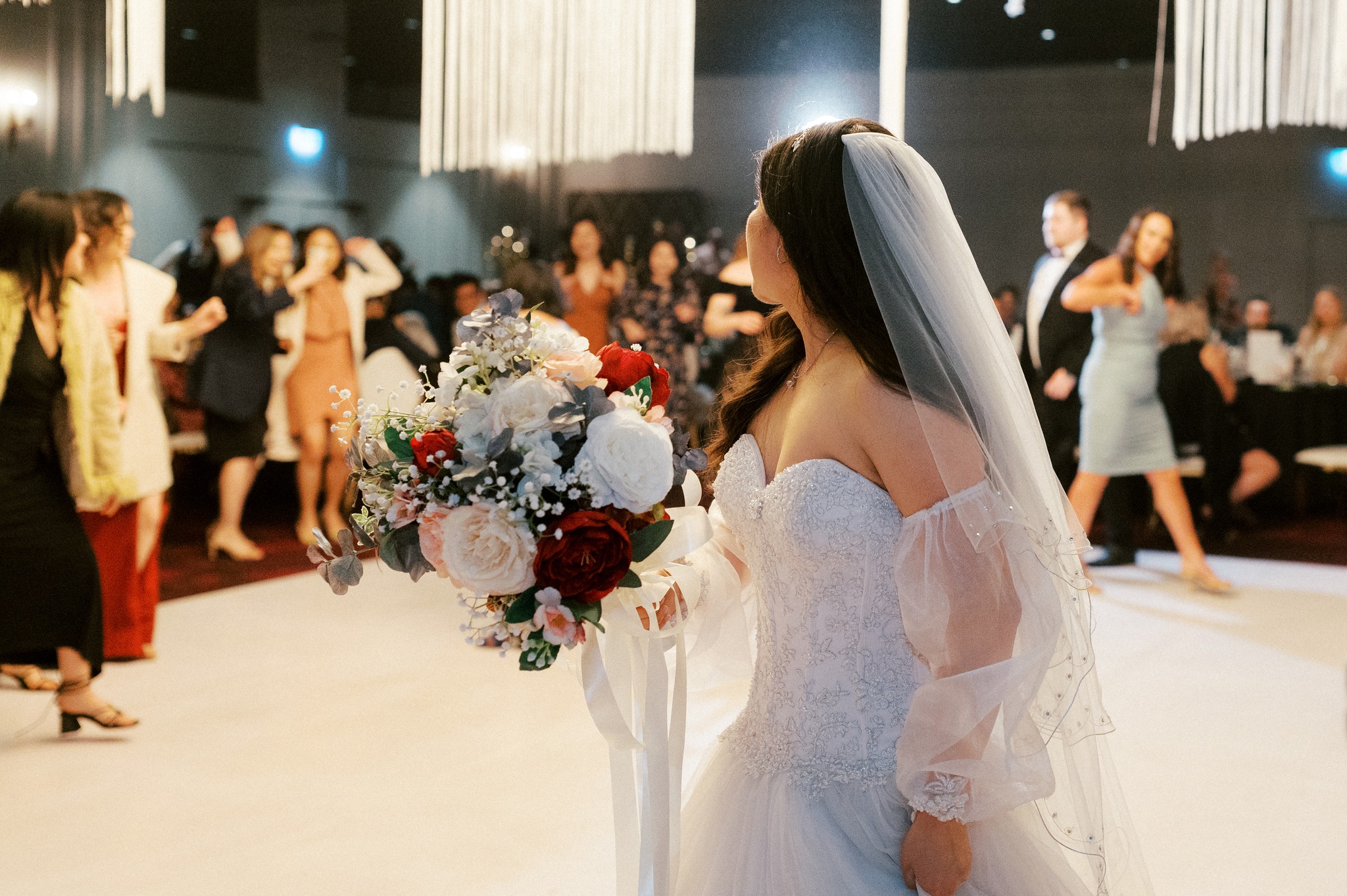 Bride tossing bouquet to guests at reception