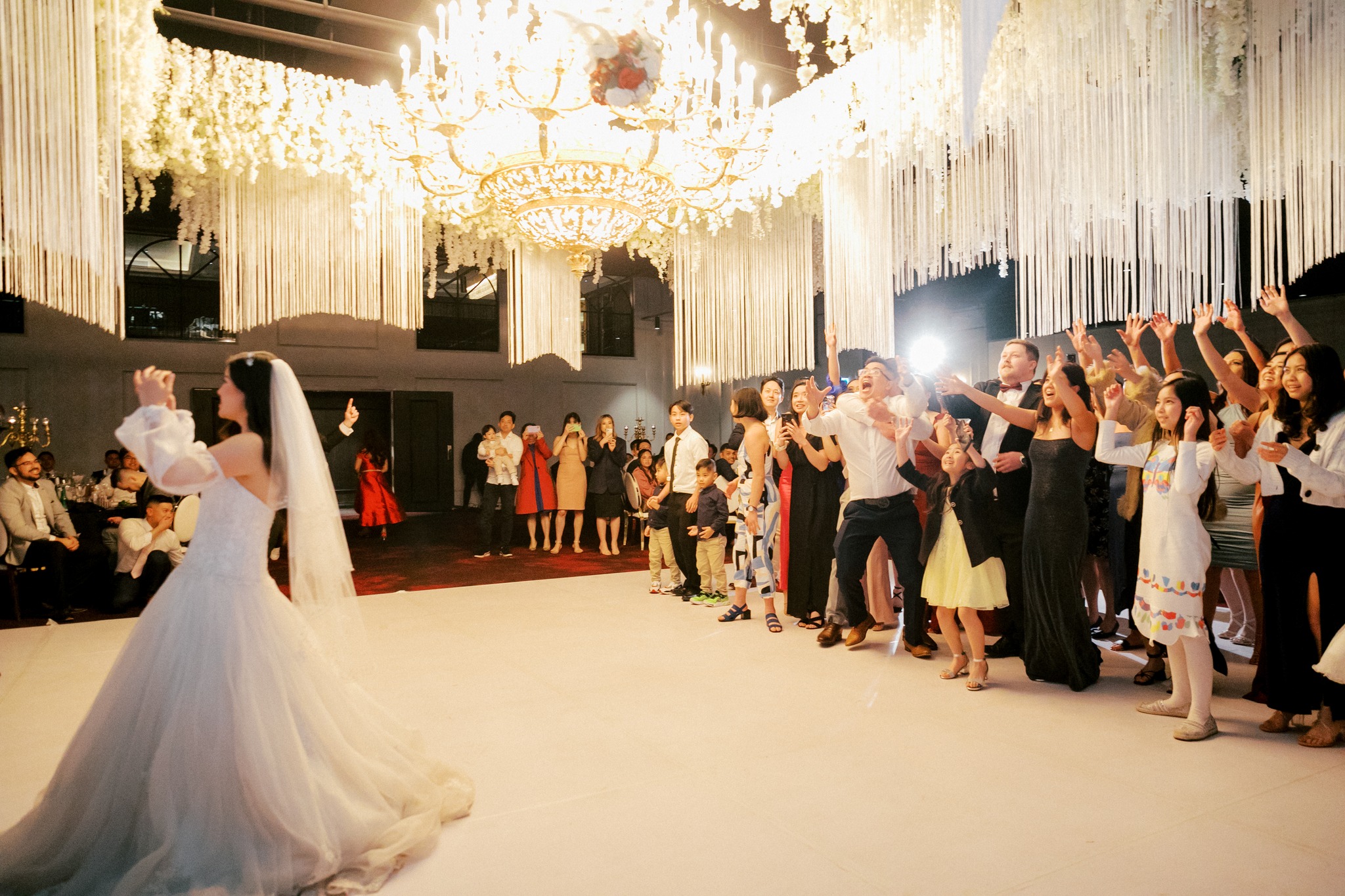 Bride tossing bouquet to guests at reception