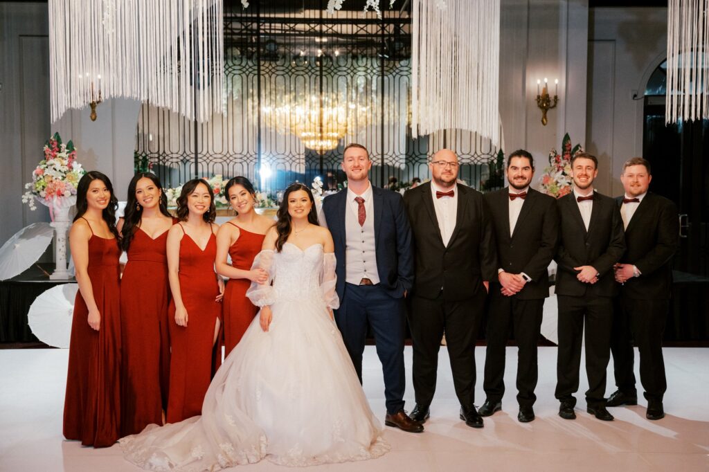 Bride and groom with bridal party indoors elegant wedding venue