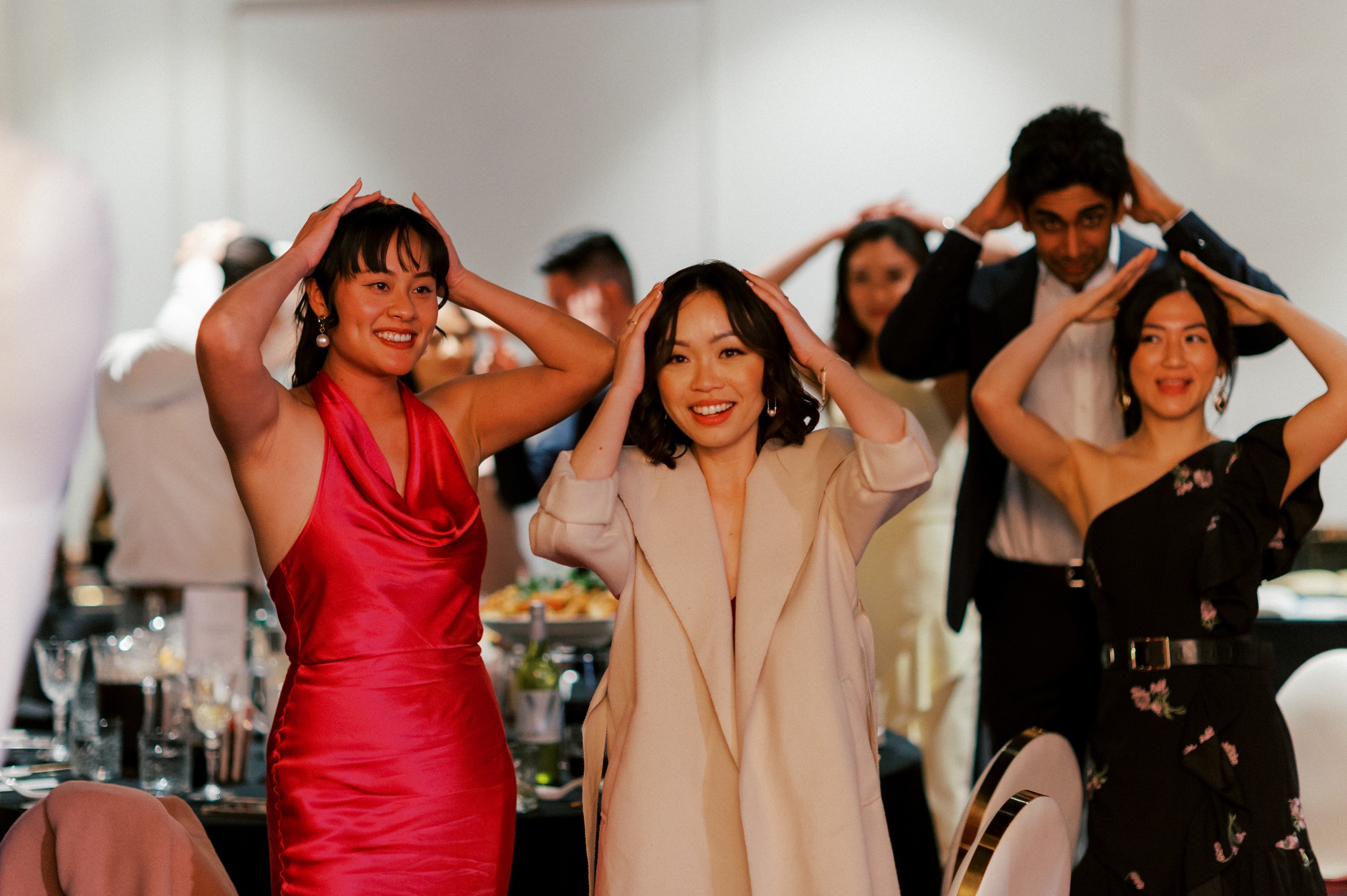 Guests dancing with hands on heads at reception