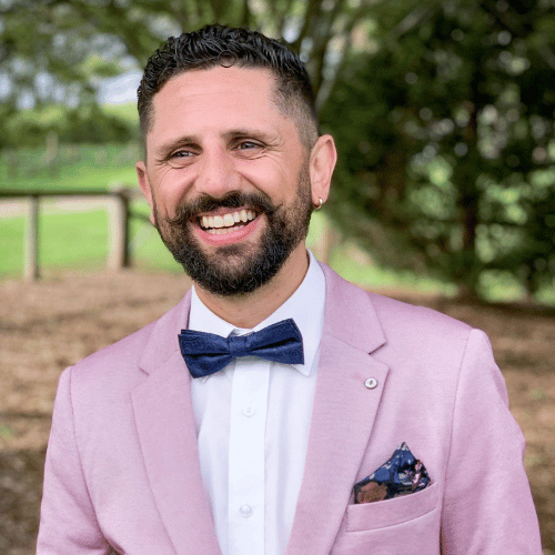 Smiling bearded man in pink suit outdoors