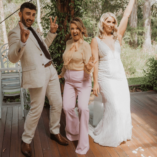 Three adults celebrating at outdoor wedding reception